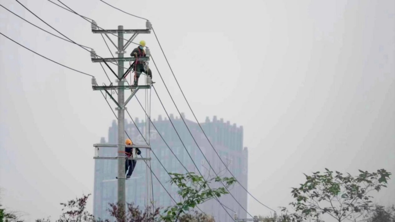 施工現場電力工人正在架設線路。向江微攝