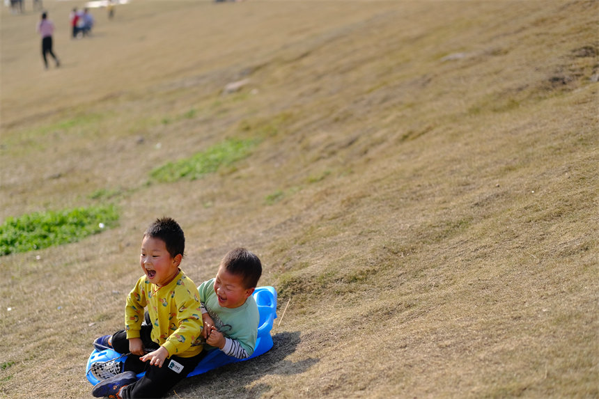 孩子們沐浴著陽光，在草坪上盡情撒歡。郭旭攝