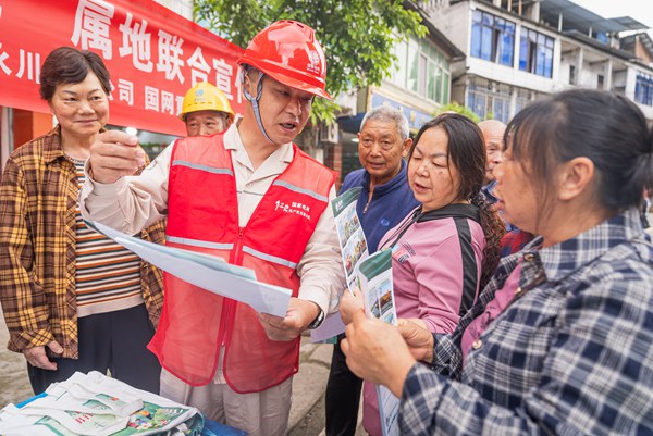 政、警、企相關人員向群眾發放宣傳手冊、介紹安全知識。國網重慶永川供電公司供圖