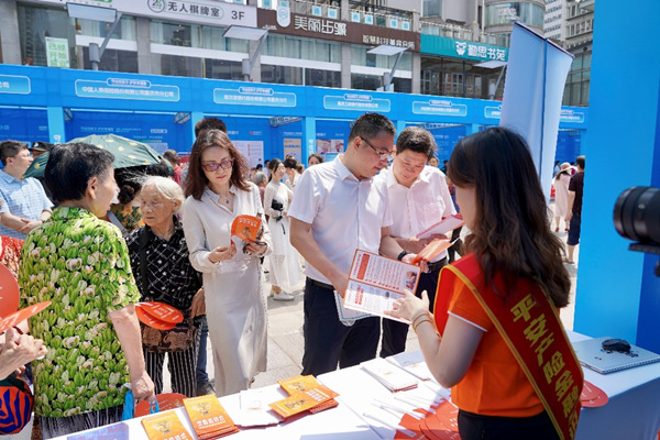 平安產險重慶分公司在活動現(xiàn)場設置宣傳展臺，發(fā)放宣傳折頁。平安產險重慶分公司供圖