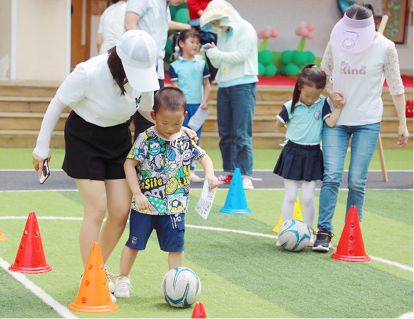 親子足球游戲。科學城七彩幼兒園供圖