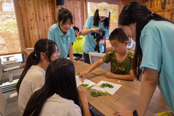 小分隊成員與小朋友們共同繪制花草貼畫。西南大學供圖